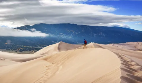 student standing in the great sand dunes