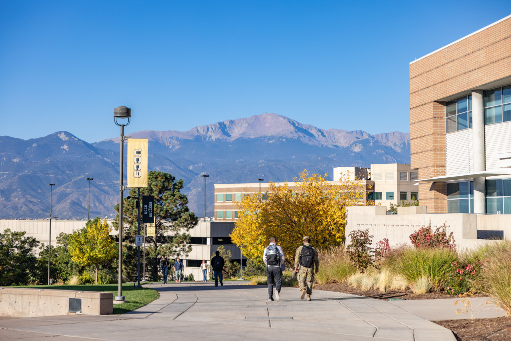 students walking on campus with mountains in the background