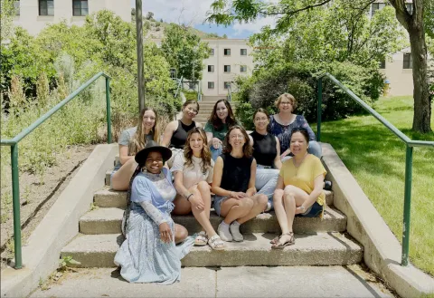 Students sitting on steps outside.